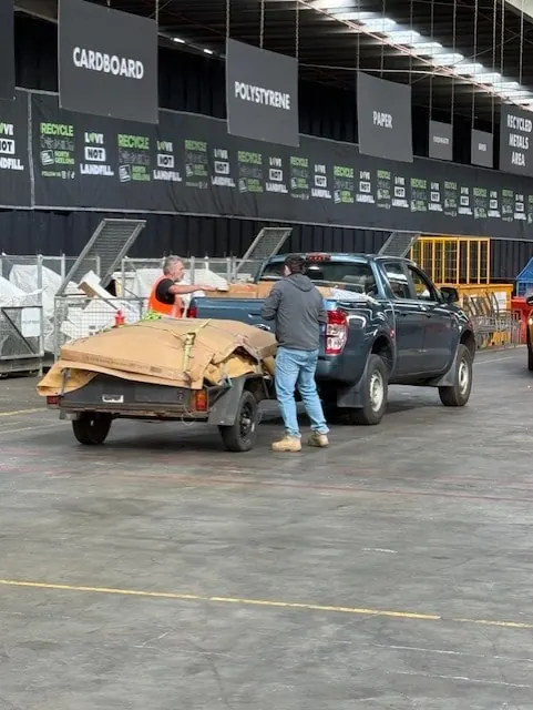 A Recycle North Geelong staff member helping a customer unload a trailer